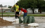 Des habitants remplissent des sacs de terre  pour empêcher l'eau d'entrer dans les  habitations à Houma, au passage de l'ouragan Francine, le 11 septembre 2024 en Louisiane