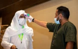 Photo fournie par le ministère saoudien du Hajj, le 25 juillet 2020, montrant un employé prenant la température d'un pèlerin, dans un hôtel de La Mecque, en Arabie Saoudite