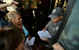 Des partisans du président autoproclamé Juan Guaido (G) distribuent des exemplaires du texte d'amnistie proposé aux militaires qui désavoueraient le président vénézuélien Nicolas Maduro, à Caracas le 27 janvier 2019
