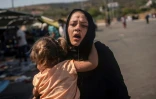 Une femme et sa fillette se sauvent après des heurts entre migrants et policiers dans le camp de réfugiés près de Mitylène sur l'île de Lesbos, le 12 septembre 2020