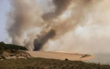 De la fumée s'élève de l'incendie qui ravage la forêt de pins en contrebas de la dune du Pyla, en Gironde, le 18 juillet 2022