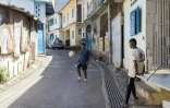 Deux garçons jouent au foot dans une rue de Kawéni, près de Mamoudzou, à Mayotte, le 26 avril 2023