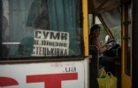 Un chauffeur de bus attend des passagers dans la localité de Stetskivka, proche de la ligne de front, dans le nord-est de l'Ukraine, le 12 juin 2025 