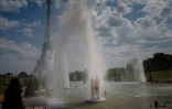 Un couple se rafraîchit sous les jets d'eau du Trocadéro, à Paris, le 26 juin 2026
