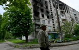 Un homme passe devant un immeuble détruit à Kharkiv, le 21 mai 2022