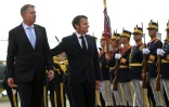 Le président français Emmanuel Macron (d) et son homologue roumain Klaus Iohannis passent en revue la garde d'honneur à la base aérienne Mihail Kogalniceanu, près de Constanta, le 15 juin 2022 en Roumanie