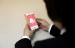 Une responsable de la police tient un téléphone contenant l'application "Digi police", à Tokyo, le 13 mai 2019