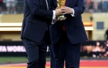 Le président de la Fifa Gianni Infantino (à gauche) et le président américain Donald Trump tiennent le trophée de la Coupe du monde 2026 avant de le remettre à l'Espagne, championne du monde le 19 juillet 2026 à East Rutherford (Etats-UNis)
