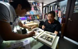 Kim Ik-Je (d), montre son album de photos, lors d'une visite de la Croix-Rouge venue enregistrer, le 9 septembre 2015 à Séoul, un message pour son frère, resté au nord depuis la guerre de Corée (1950-1953)
