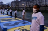 Un militant écologiste participe à une action le 14 janvier 2021 à Paris pour attirer l'attention sur le procès intenté à l'Etat par plusieurs ONG