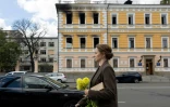 Une femme marche le 5 octobre 2026 devant le bâtiment de l'Académie nationale des sciences à Kiev endommagé par une frappe russe