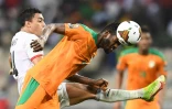 Le milieu de terrain ivoirien Ibrahim Sangaré devance l'attaquant égyptien Mostafa Mohamed, lors de leur 8e de finale de la Coupe d'Afrique des nations, le 26 janvier 2022 à Douala (Camerou)