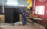 Une femme quitte l'isoloir lors des élections législatives au Sénégal, un important test pour le pouvoir.
