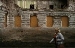 Une femme passe à proximité d'un bâtiment détruit par un bombardement russe, le 12 juin 2025 à Soumy, dans le nord-est de l'Ukraine 