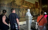Des touristes admirent une peinture de Jean-Bapstiste Vermay, Ă La Havane, Ă Cuba, le 12 avril 2019