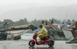 Un homme en scooter sous une pluie battante à Yilan, le 11 novembre 2025, alors que le typhon Fung-Wong approche de Taïan