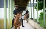 Des écuyers du Cadre Noir de Saumur quittent les écuries pour un spectacle matinal, le 5 juin 2025 dans le Maine-et-Loire