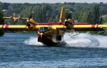 Un Canadair CL-415 de la Sécurité civile effectue des manœuvres d'écopage au-dessus de la Seine à Chartrettes, pour lutter contre un incendie dans la forêt de Fontainebleau, le 13 juillet 2026 en Seine-et-Marne