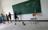 Des enfants jouent au foot dans une salle de classe d'une école à Tyr dans le sud du Liban, transformée en refuge pour les déplacés, le 19 octobre 2023 