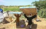 Une famille de déplacés au Yémen porte des matelas après avoir dû fuir sa maison en raison des combats entre les Houthis et les forces gouvernementales à Hajjah, le 7 octobre 2026