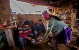 L'agriculteur péruvien Saul Luciano Lliuya (G), son fils Brandon (C) et son épouse Lidia se restaurent dans leur ferme de Huaraz, dans le nord-est du Pérou, le 24 mai 2022