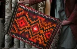 Un marchand montre un tapis dans sa boutique de Bamiyan, le 7 janvier 2021 en Afghanistan