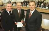   Sur cette photo prise le 10 avril 1998, le Premier ministre britannique Tony Blair (R), le sénateur américain George Mitchell (C) et le Premier ministre irlandais Bertie Ahern posent pour une photo après avoir signé l'accord du Vendredi saint