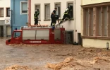 Des pompiers pénètrent dans une maison indonée par les fenêtres du premier étage, le 15 juillet 2021 à Trier, dans l'ouest de l'Allemagne