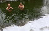 Erina Hey et Franz Mayr se baignent dans les eaux glaciales de la rivière Eisbach dans l'English Garden park de Munich, le 16 janvier 2021