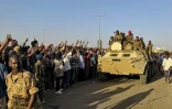 Des manifestants soudanais font le signe de la victoire en direction de militaires de l'armée à Khartoum, le 7 avril 2019