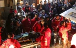 Des volontaires du Croissant-rouge syrien transportent un malade dans une ambulance pour l'évacuer de Douma vers Damas où il doit recevoir des soins, tard le 28 décembre 2017