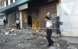 Devant l'immeuble où le corps de trois personnees tuées dans les troubles ont été découverts dans le quartier chinois de Honiara, le 27 novembre 2021