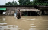 Une femme patauge dans une rue inondée de la commune de Bago, en Birmanie, le 12 août 2023
