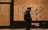 Un graffiti sur un panneau en bois protégeant un commerce, le 4 novembre 2020 à New York
