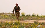 Un combattant des Forces démocratiques syriennes court avec son arme lors d'une opération contre le groupe Etat islamique, près de Baghouz en Syrie, le 14 février 2019