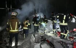 Des pompiers sur le site d'un entrepôt de la compagnie postale Nova Poshta endommagé par un bombardement russe dans un village près de Kharkiv, le 13 janvier 2026 en Ukraine