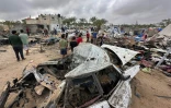 Des Palestiniens au milieu des dégâts dans le camp de déplacés à Al-Mawassi visé par des frappes israéliennes, dans le sud de la bande de Gaza, le 18 mai 2025
