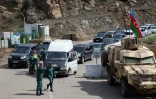 Des soldats azerbaïdjanais régulent le flot de véhicules de réfugiés quittant le Nagorny Karabakh pour entrer en Arménie, au corridor de Latchine, le 26 septembre 2023