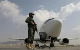 Un taliban armé monte la garde près d'un avion d'Ariana Afghan Airlines sur le tarmac de l'aéroport de Kaboul, le 12 septembre 2021