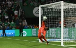 Le gardien auxerrois Donovan Leon détourne le tir du milieu de terrain algérien de Saint-Etienne, Ryad Boudebouz, lors de la séance de tirs au but, à l'issue des prolongations (1-1), en match retour du barrage L1/L2 pour l'accession en L1, le 29 mai 2022 au Stade Geoffroy-Guichard