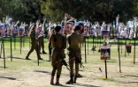 Des soldats israéliens rendent hommage à des personnes enlevées ou tuées par le Hamas, et dont des photos sont exposées sur le site du festival Nova à Re'im, dans le sud d'Israël