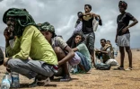 Des migrants éthiopiens se reposent, le 12 avril 2026, dans une zone désertique de Djibouti après avoir reçu de l'aide de la part de l'Organisation internationale pour les Migrations (OIM)