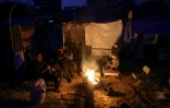 Des Palestiniens tentent de se réchauffer autour d'un feu, à Jabalia, dans le nord de la bande de Gaza, le 17 février 2025