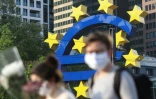 Des passants portent des masques de protection près du siège de la Banque centrale européenne à Francfort, le 24 avril 2020 en Allemagne