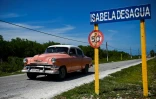Une vieille voiture américaine face au panneau de Isabela de Sagua, à Cuba le 27 avril 2022