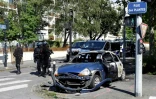Des policiers près d'une voiture brûlée dans le quartier du Breil à Nantes le 4 juillet 2018