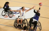Denis Gargaud Chanut (c.), champion olympique de canoë-kayak en 2016, joue au basket-ball en fauteuil roulant lors d'une rencontre d'exhibition organisée au Palais des Sports de Bordeaux, le 23 novembre 2023