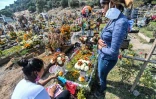 Des femmes ornent la tombe d'une victime du Covid à Valle de Chalco (Mexique) le 28 octobre 2020