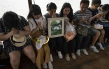 Des éplorés assistent à l'incinération de leurs animaux de compagnie le 5 novembre 2017, avant de déposer leurs cendres dans la rivière de Chaopraya à Bangkok