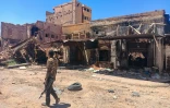 Un combattant fidèle à l'armée marche au milieu des ruines à Khartoum, le 24 mars 2025